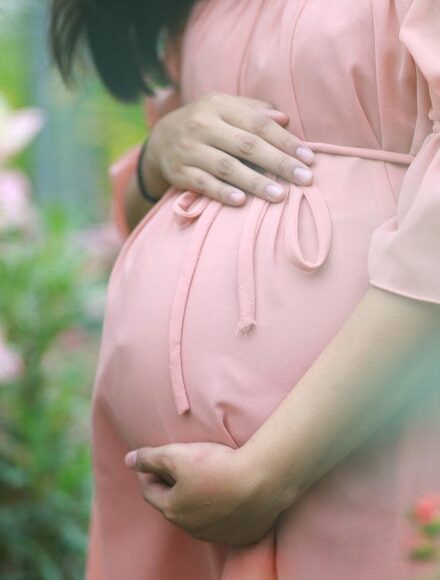kobieta w ciąży w różowej, letniej sukience